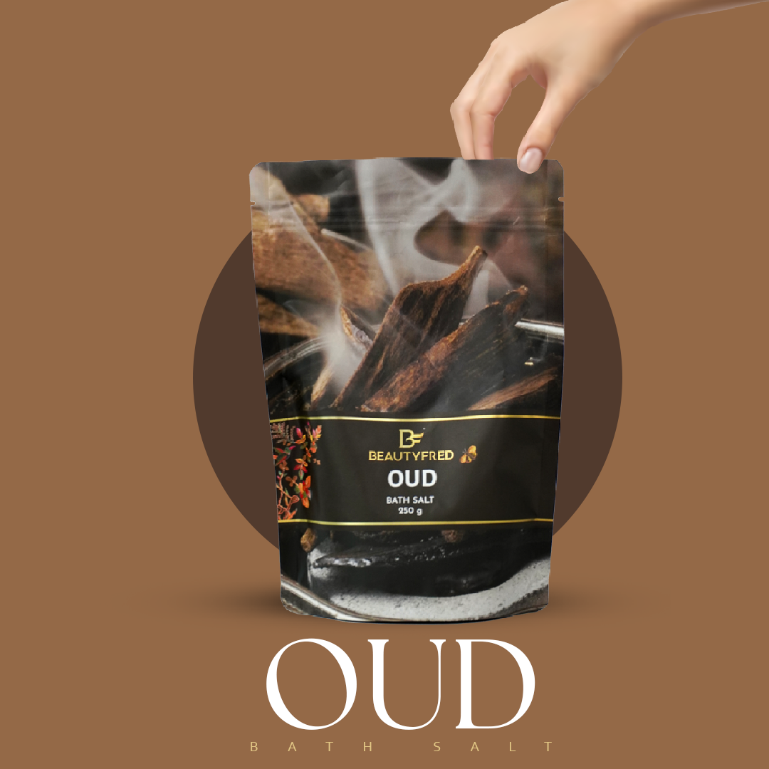 Oud bath salt packaging with a hand holding it against a brown background