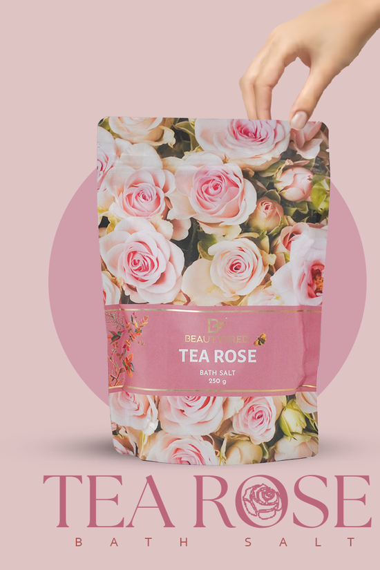 Tea Rose bath salt packaging with a hand holding it against a pink background
